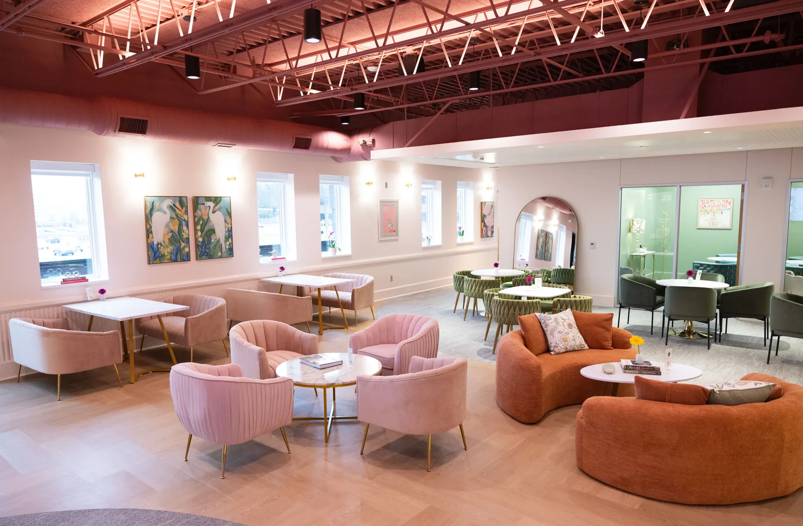 The Legacy Collective workshop venue in Omaha, with pink seating, orange sofas, and tables for working together